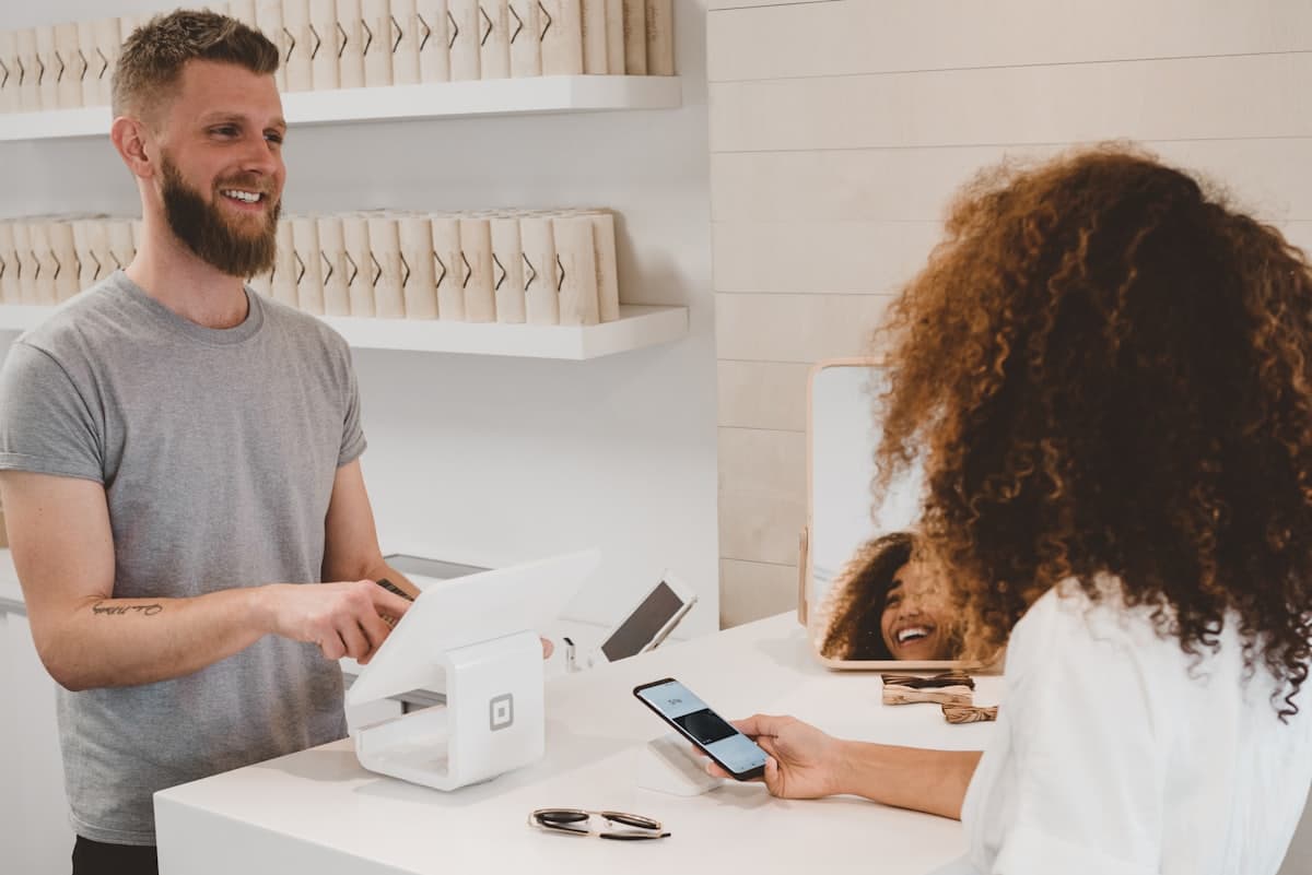 A shop owner completing a card payment at a counter terminal